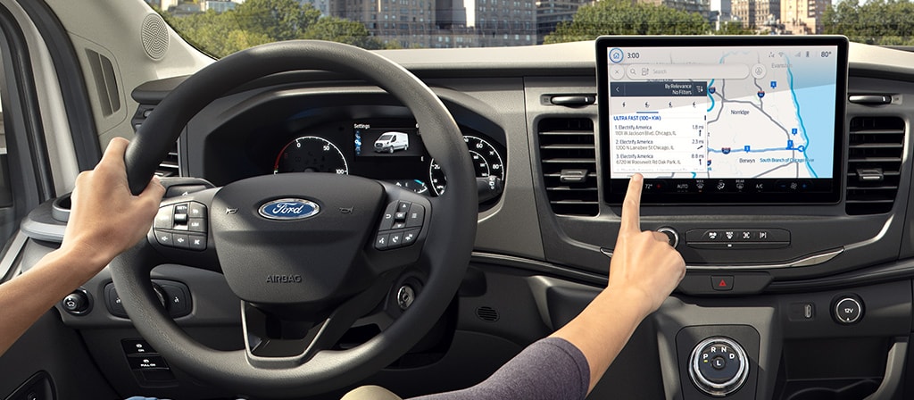 A driver parked and touching the interior computer screen