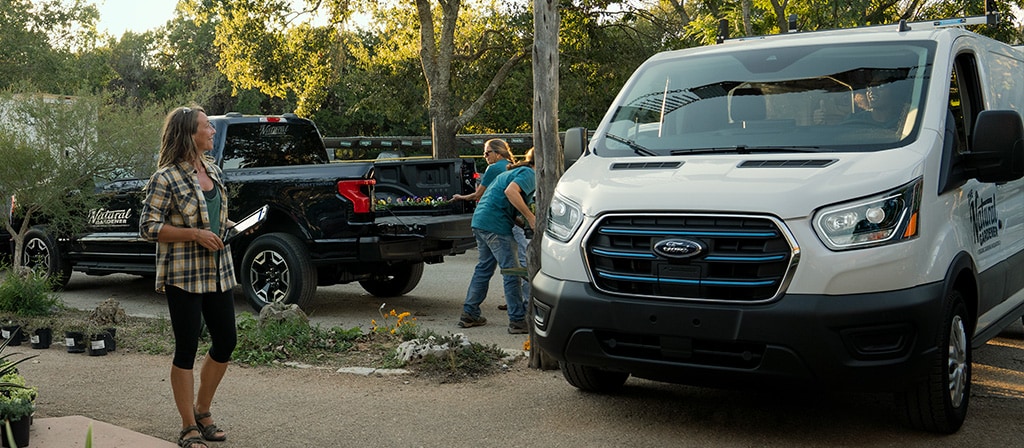 A white 2025 Ford E-Transit™ van parked and being loaded at a garden nursery