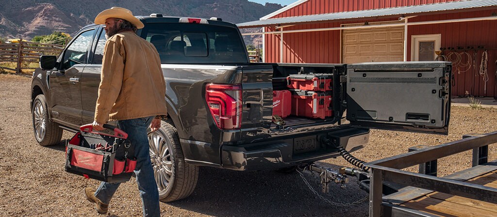 Person walking near a 2025 Ford F-150® pickup with the Pro Access tailgate open