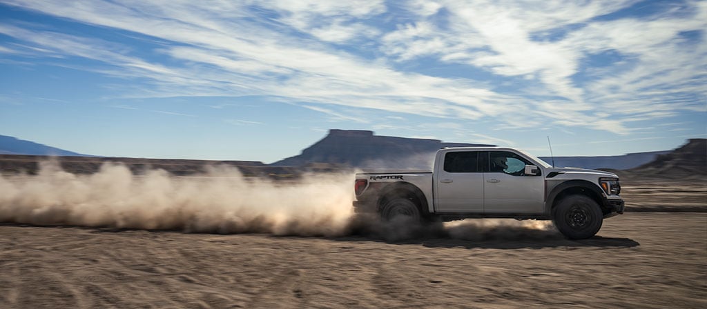 2025 Ford F-150® Raptor® R™ racing across the desert leaving a trail of dust behind