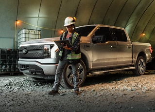 White hard hat worker in front of truck on worksite