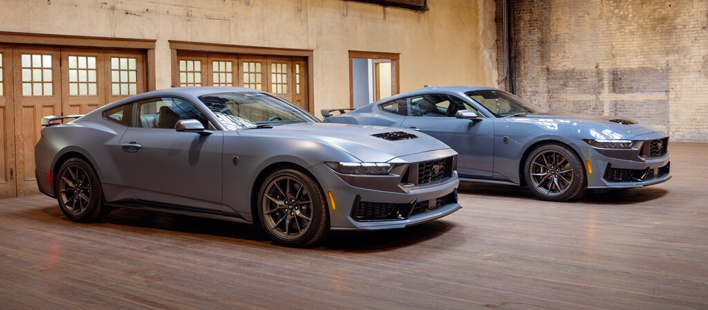 Two 2026 Ford Mustang® fastbacks parked in a garage, one with the available Matte Clear Film