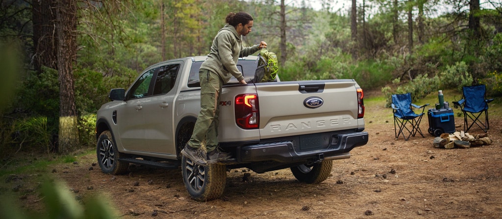 A person using the integrated box side step feature on the 2025 Ford Ranger®