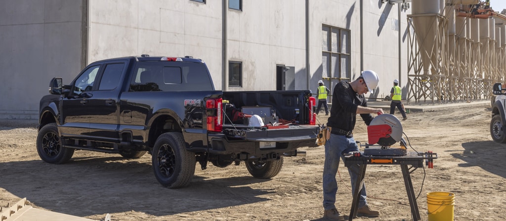 2026 Ford Super Duty® F-250® XL pickup with the STX® Appearance Package parked on a construction site with a person working nearby