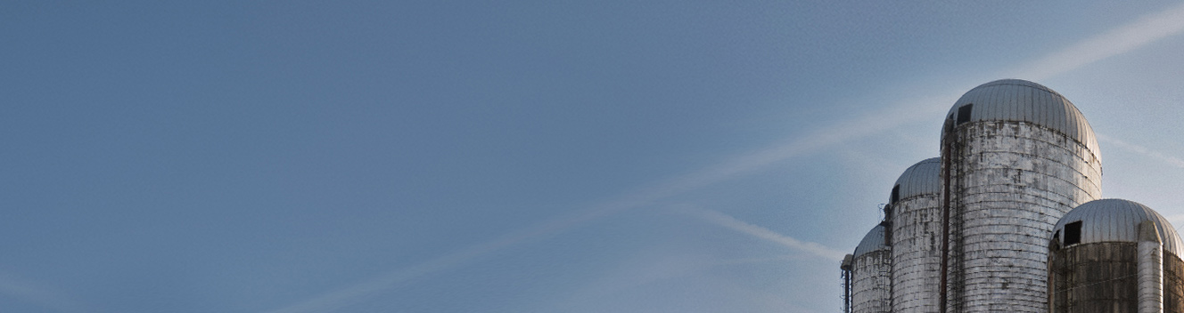 Light blue sky with a cluster of silos on the far right