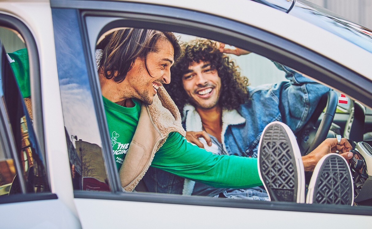 Two men smiling in a vehicle