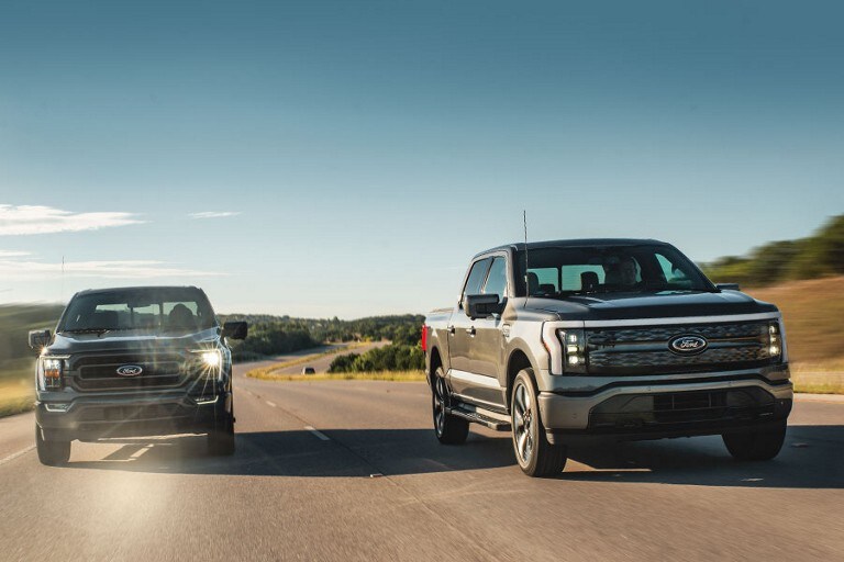 Two Ford F-150® pickups being driven on the road