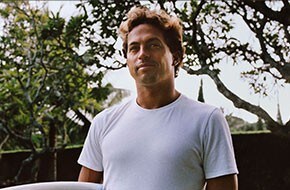 Close-up of Kai Lenny holding a surfboard