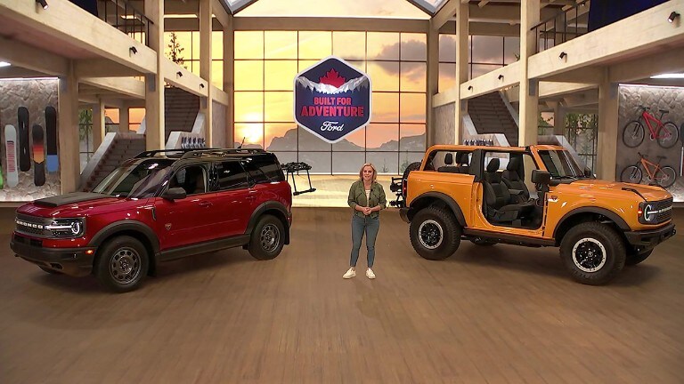 A woman stands between a red 2021 Ford Bronco and a yellow 2021 Ford Bronco Sport