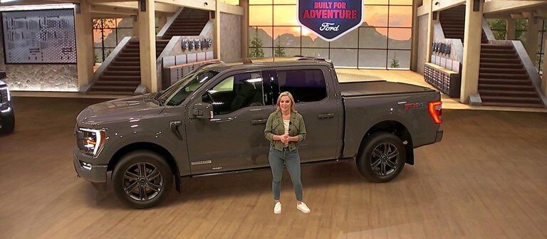 A woman stands next to a grey 2021 Ford f 1 50