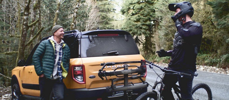 Two men stand next to a yellow 2021 Ford Bronco Sport