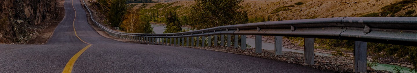 A two lane highway winds towards mountains in the distance