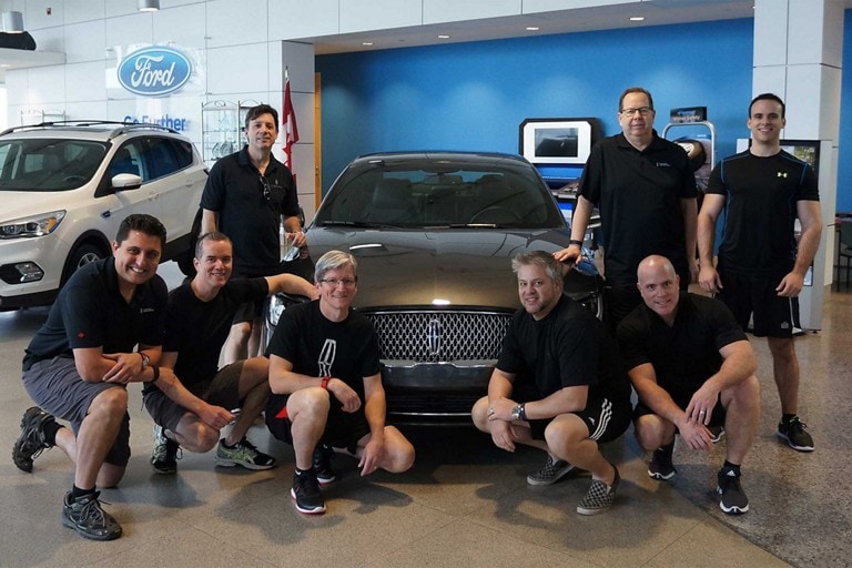 Ford / Lincoln employees pose in front of the Lincoln Town Car