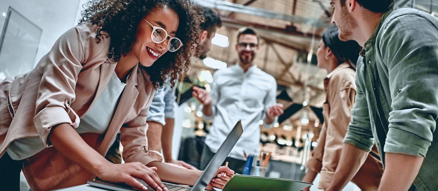 A group of young office workers collaborate around a table