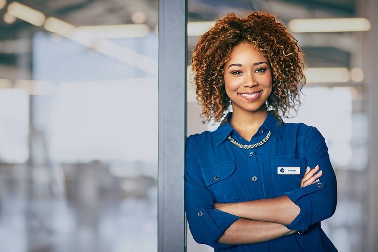 A Ford employee leans with arms crossed