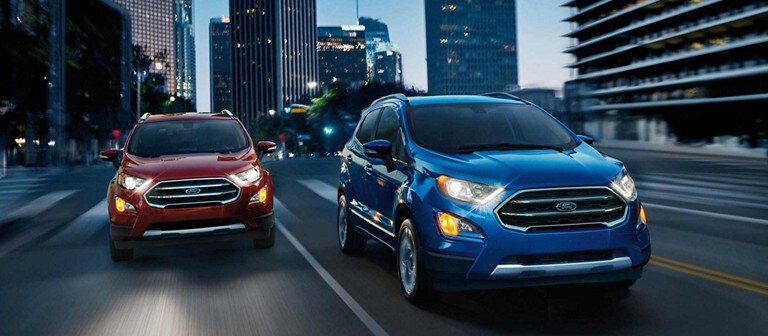 Two Ford EcoSports driving on a city street at night