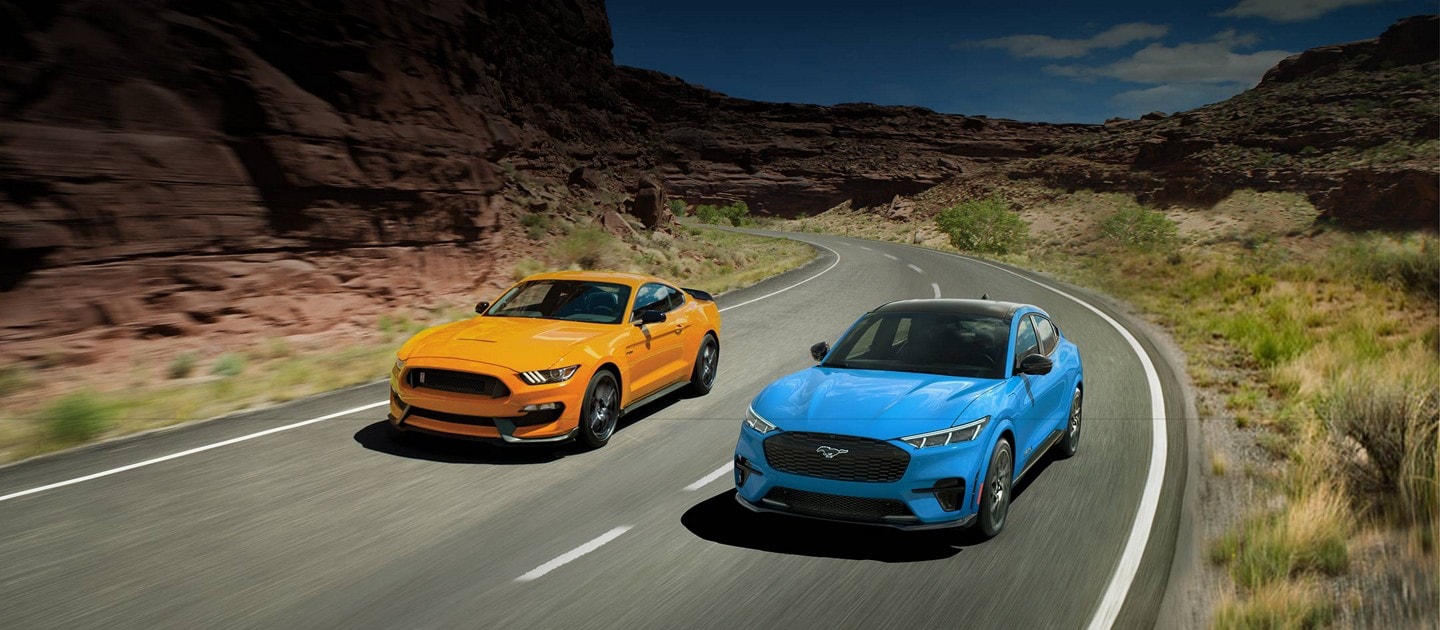 A 2021 Ford® Mustang GT 350 and a 2021 Ford® Mustang Mach-E driving down a two-lane road