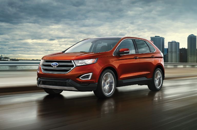 Ford vehicle cruising along lakeside road