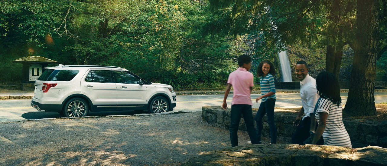 Young family at park with Ford vehicle parked on street