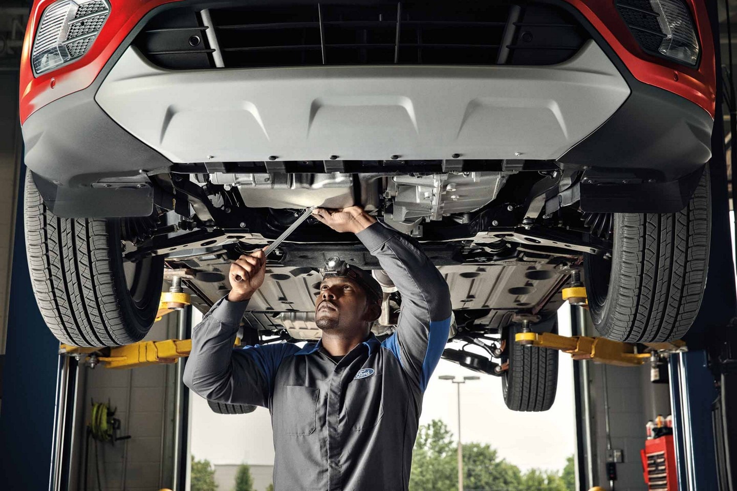 Service technician works on an electric vehicle on a lift.