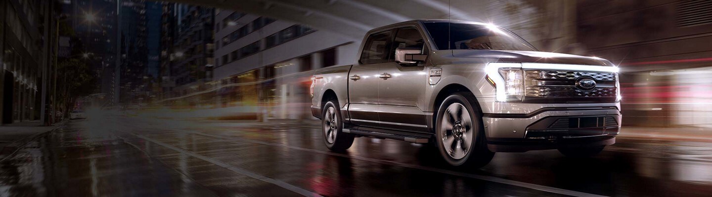 A Ford F-150 Lightening on a city street at night