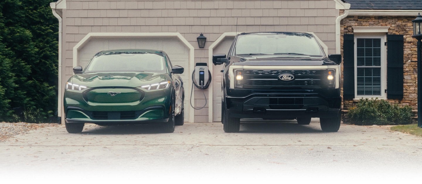 A Mustang Mach-E and a F-150 Lightning parked in a driveway