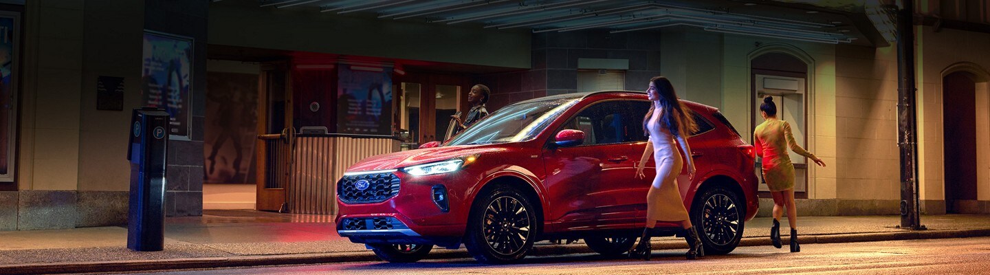 Three girls entering a red 2023 Ford Escape outside of a theatre
