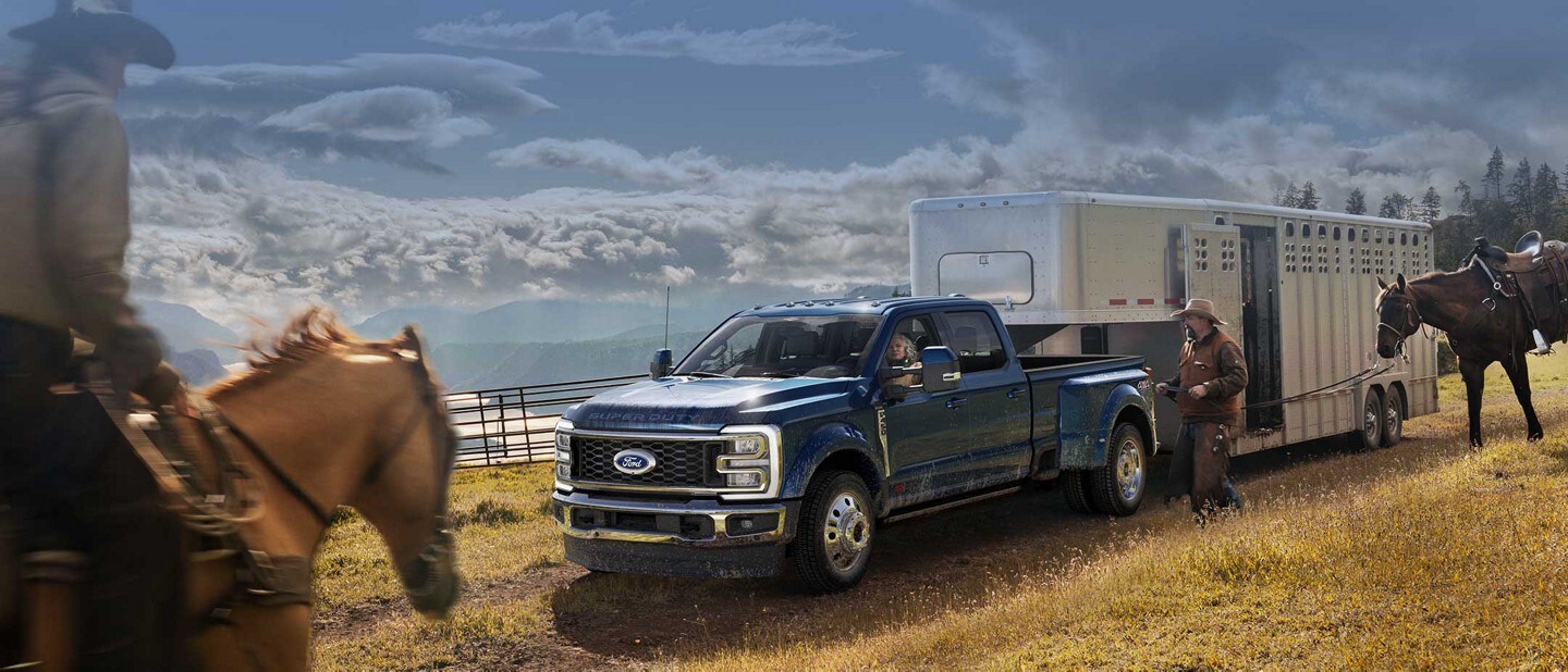 Man riding a horse toward a 2023 Ford F-450® Super Duty® King Ranch™ hitched to a horse trailer