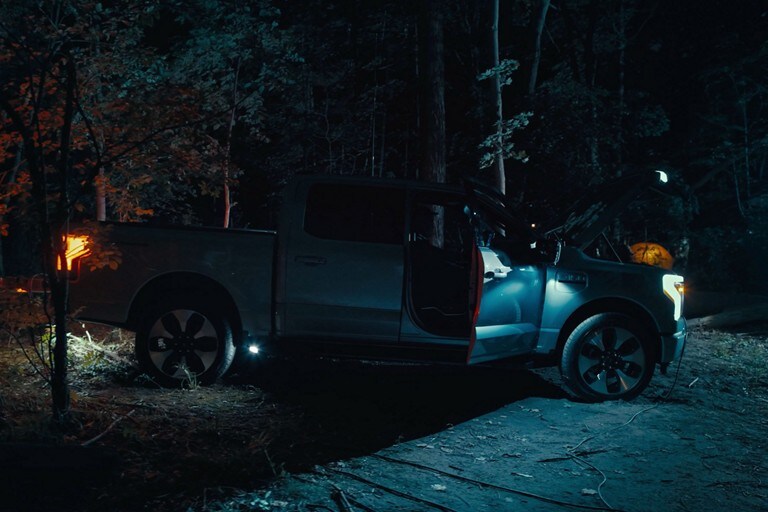 A Ford f 1 50 Lightning lights-up a campsite at night