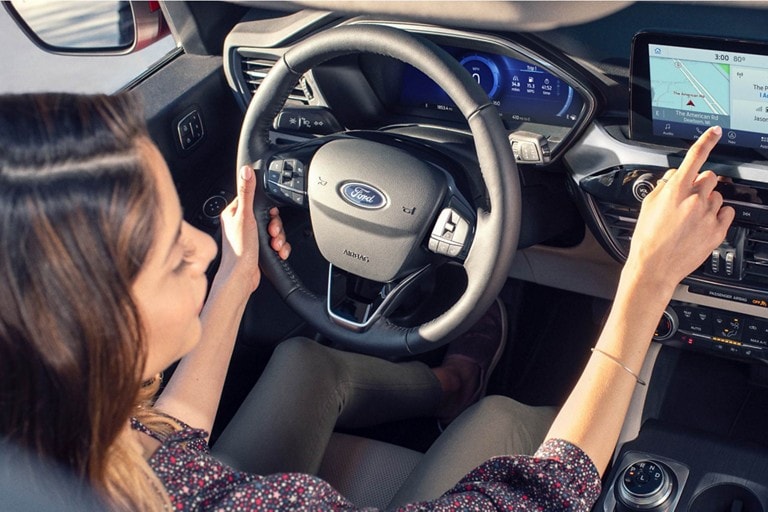 A woman driving a Ford vehicle.