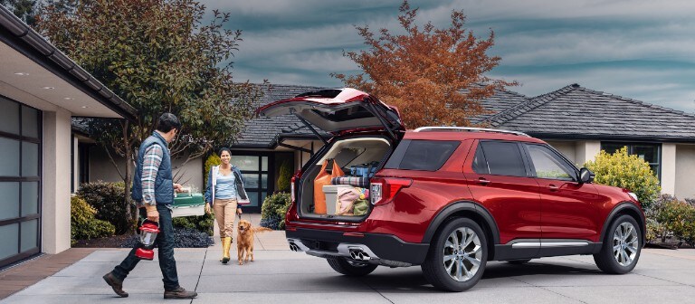 Man woman and dog near 2021 Ford Expedition in Rapid Red with open liftgate showing a trunk full of groceries