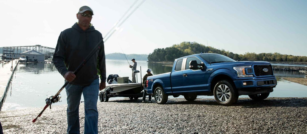 Fisherman stands with F-150 in background with a boat on a trailer