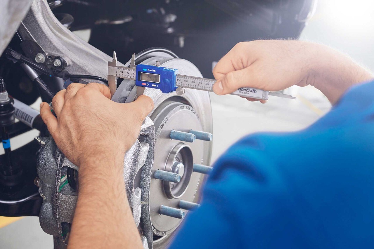 Ford technician adjusts a brake disc