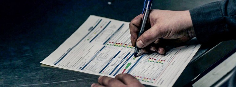 A Ford Technician filling out a vehicle report card