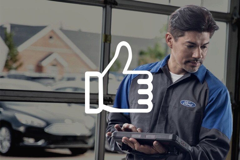 Ford Technician standing in a factory carrying a tablet computer