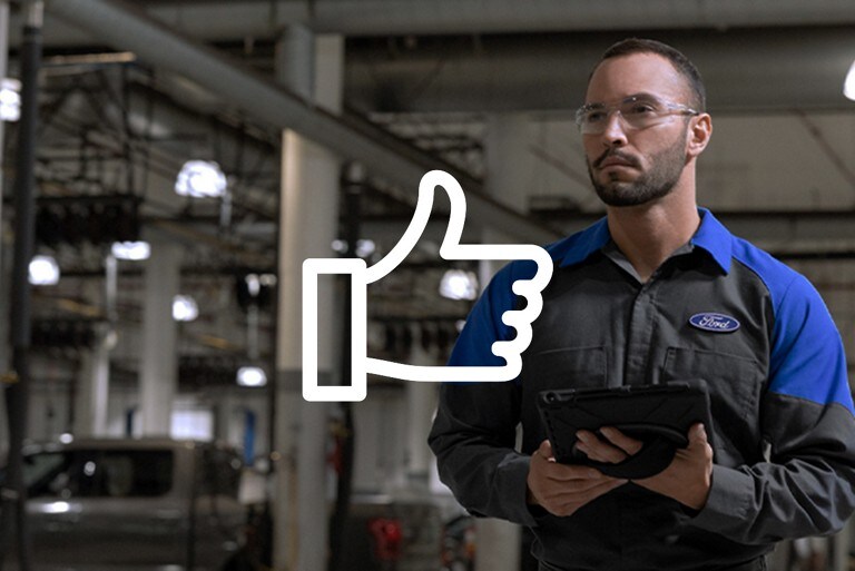 Ford Technician standing in a factory carrying a tab