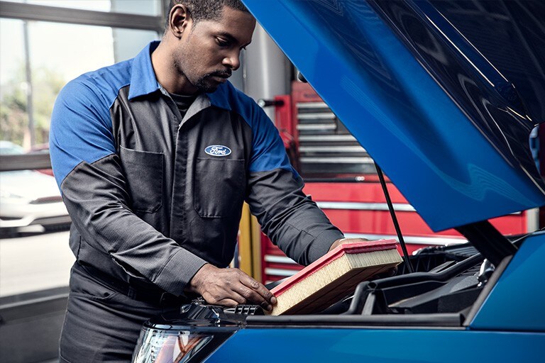 A Ford Service technician changes an air filter