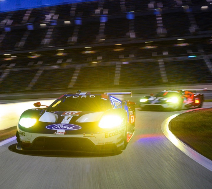 Two Ford G T vehicles on racetrack at night
