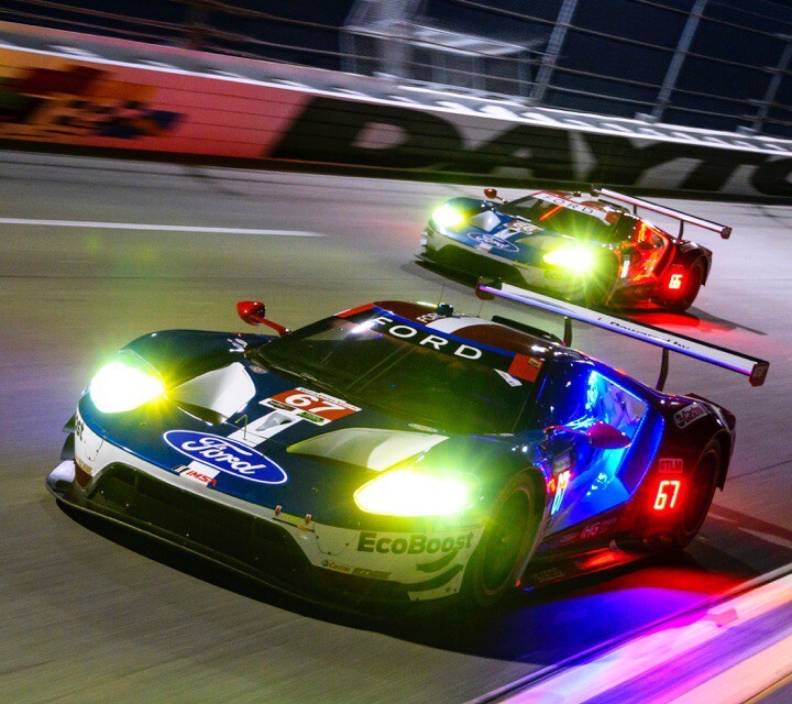 Two Ford G T vehicles on racetrack at night