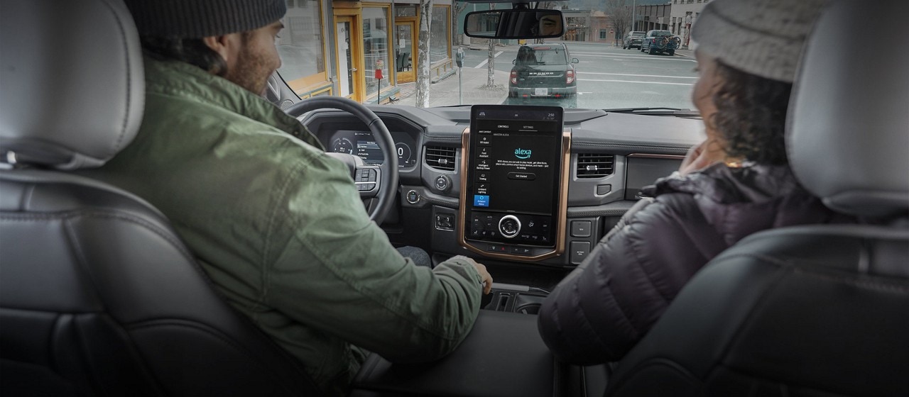 A driver and passenger in a Ford vehicle.