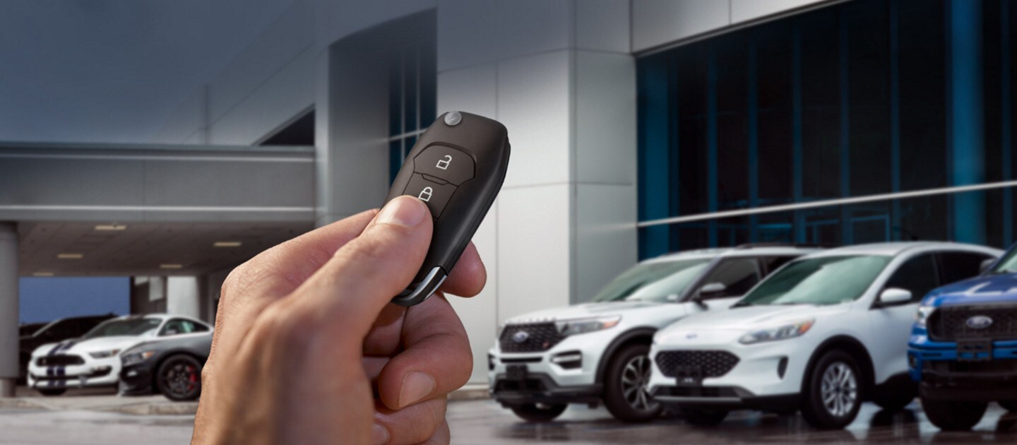 Customer’s hand holding a key fob at a Ford dealership