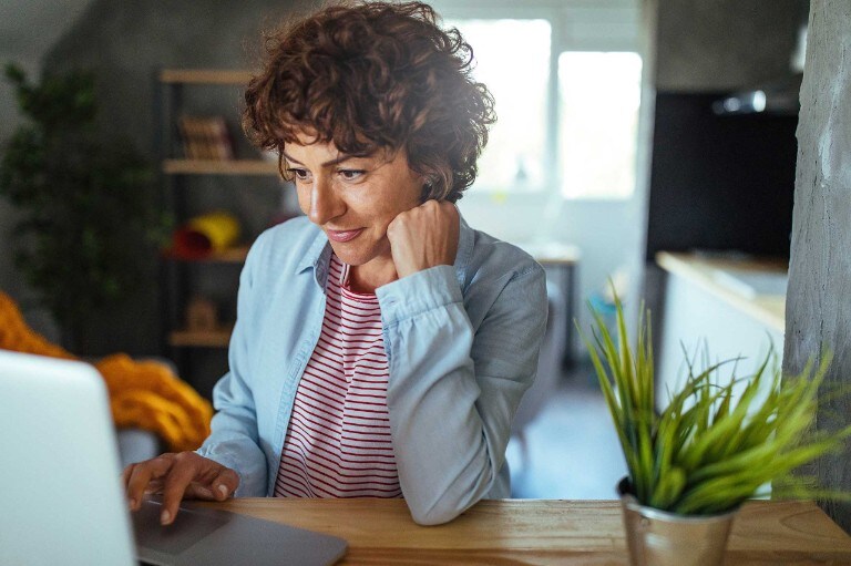 A woman uses a laptop in an home office
