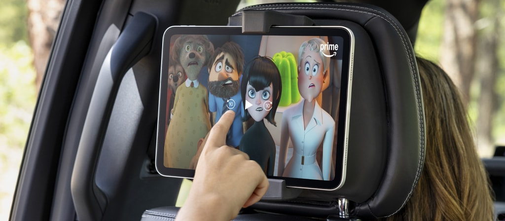Passenger using a tablet in the available second-row digital device holder in a 2025 Ford Expedition® SUV