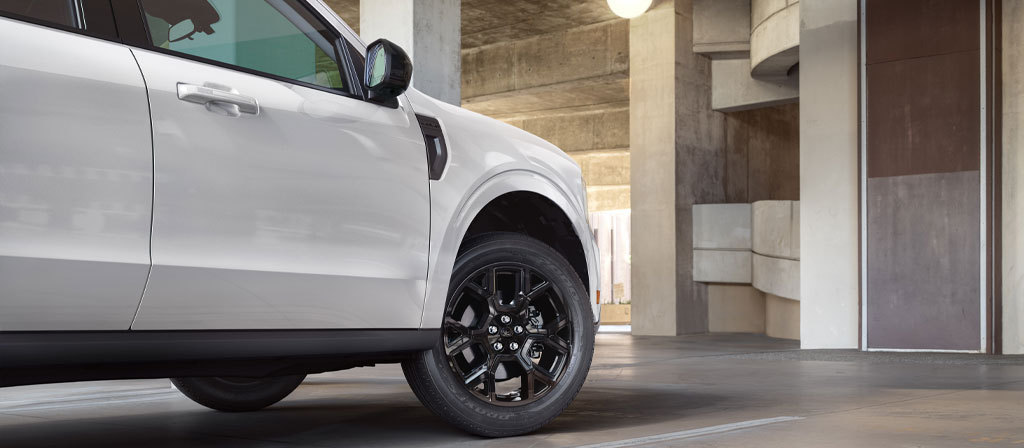 A 2025 Ford Maverick® pickup parked in front of a modern concrete structure