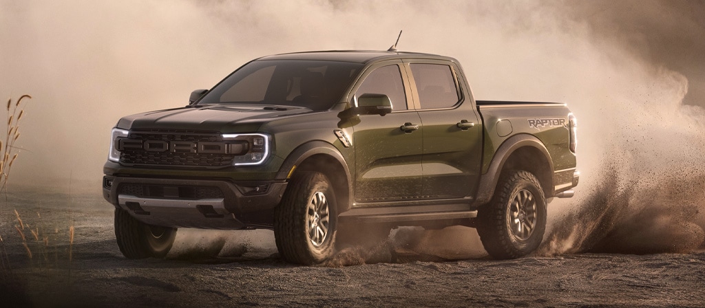 A 2025 Ford Ranger® Raptor® pickup is being driven off kicking up dust