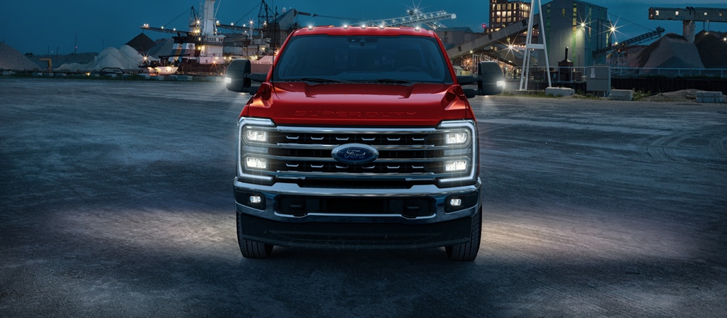 2026 Ford Super Duty® F-450® Lariat® truck with its lights on parked on a construction site at dusk