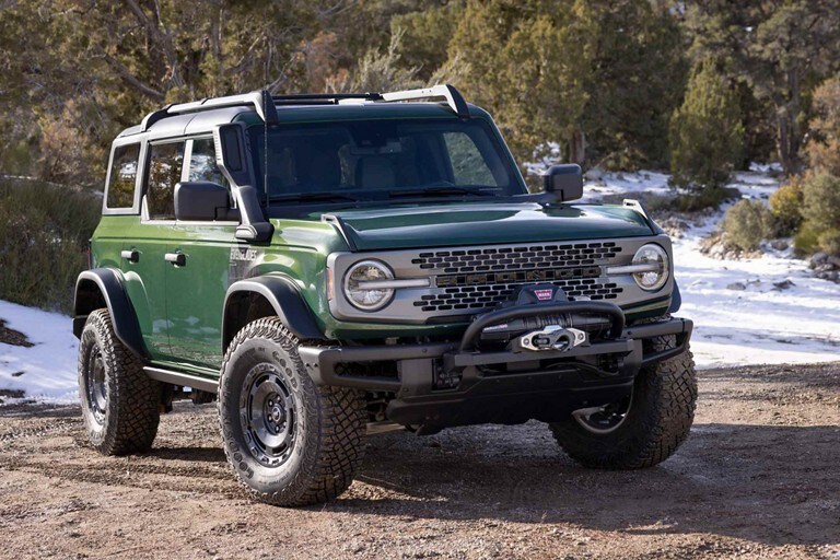 Four-door 2024 Ford Bronco® Everglades™ model with available Sasquatch® Package in Eruption Green parked on a gravel road