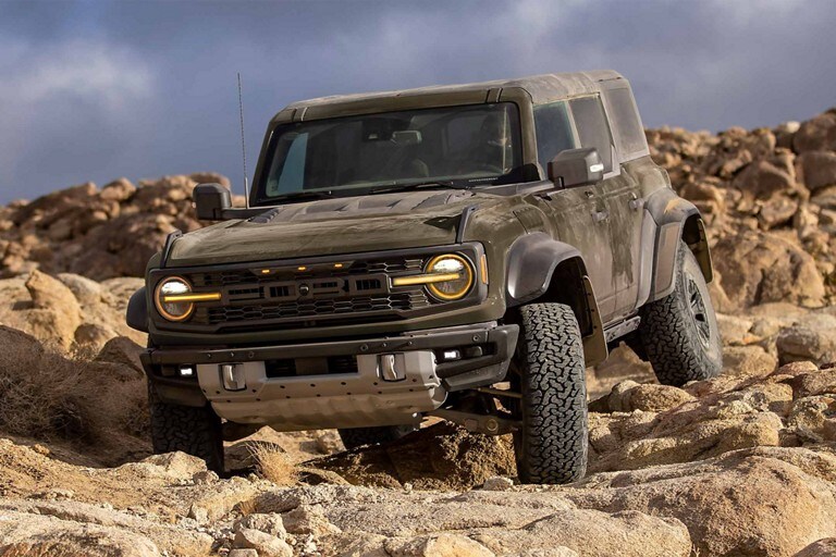 2024 Ford Bronco® Raptor® in Shelter Green driving down rocky terrain