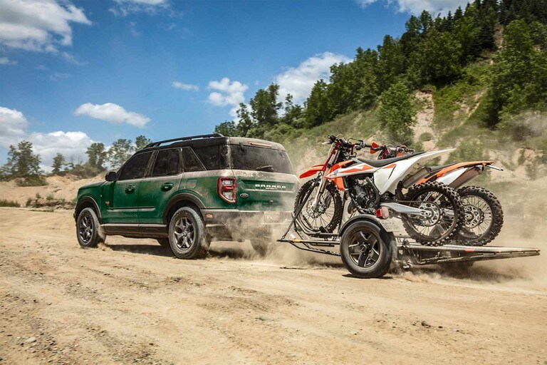 2023 Ford Bronco® Sport SUV towing dirt bikes on sandy dune