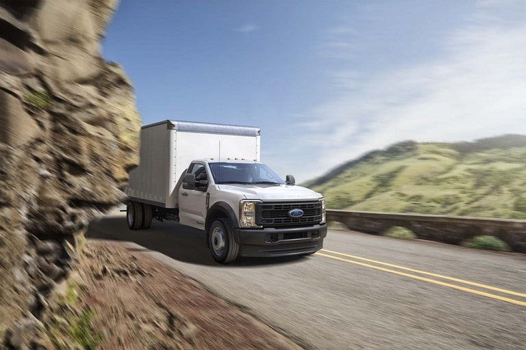 2025 Ford Super Duty® F-450® XLT with a box being driven through a tight mountain curve